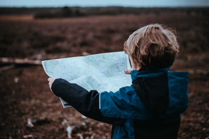 Een kind met een landkaart in een veld